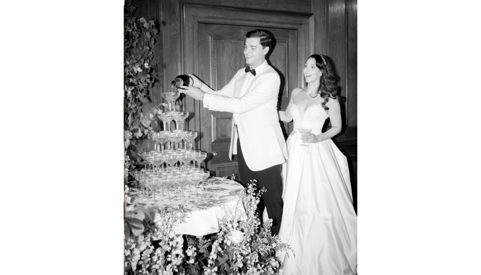 Sam & Rachel’s Old Hollywood Glam inspired London Wedding: Groom Pouring Champagne Over Tower of Glasses