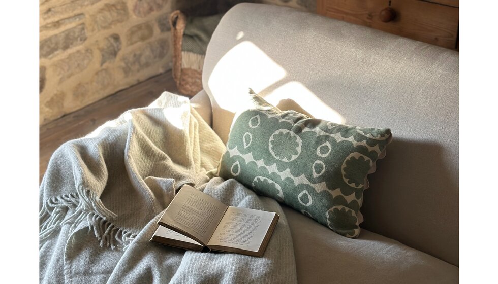 Special Wedding Gift List Ideas for the Living Room | A Cosy Corner in the Living Featuring Green Patterned Wicklewood Cushion and Woolen Blanket on a Cosy Grey Soda
