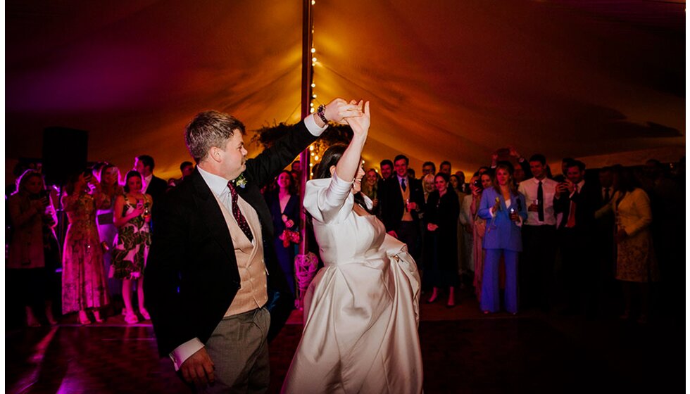The Wedding Present Company | Groom and bride's first dance on the dancefloor in the tent of their spring floral-filled wedding in Cambridgeshire