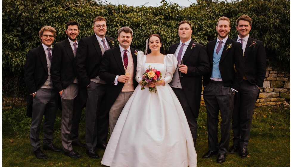 The Wedding Present Company | A bride in a Jesus Peiro gown with a groom and groom party in morning suits
