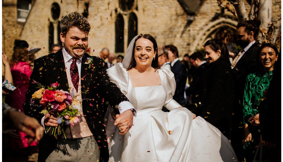 The Wedding Present Company | Bride and groom leaving traditional English church on their spring flower-filled wedding in Lincolnshire