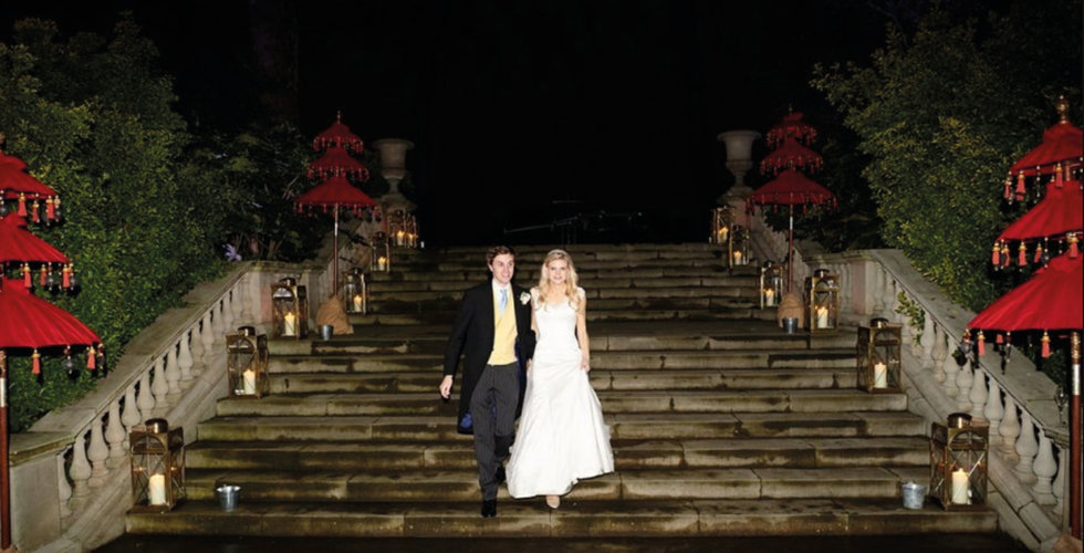 The bride and groom walk down the steps of their venue decorated in Chinese decorations as a nod to the bride's stint in Hong Kong.
